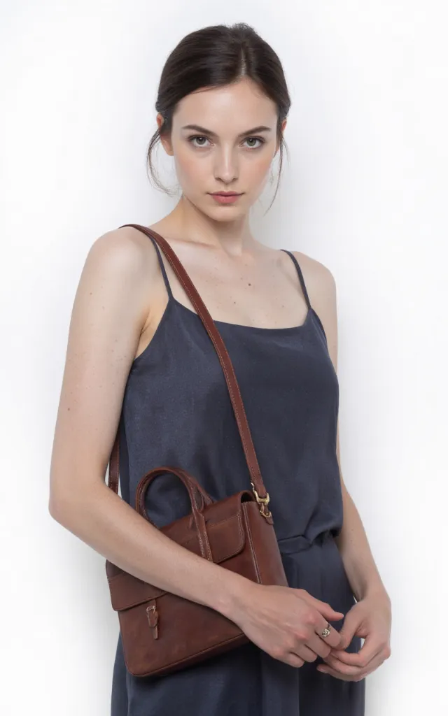 A French female model with a Handbag, wearing a dress, against a white background, in a front   facing close   up